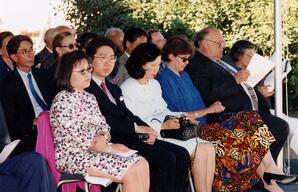 Audience members sit under gazebo