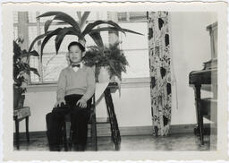 Joe takes his photo in front of a plant