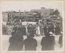 Crowd in front of church construction scaffolding and British Columbia Provincial Flag
