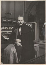 Virgil Fox posing for a photo sitting at the organ
