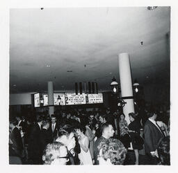 People mingling in front of a cinema marquee