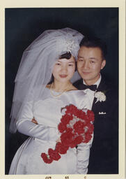 Mary and Ted holding flowers on their wedding day