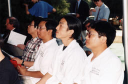 Audience members wearing UBC shirts watch ceremony proceedings