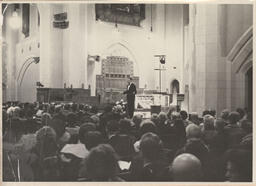 Man speaking on stage at presumably, the Organ and Christian Art Festival
