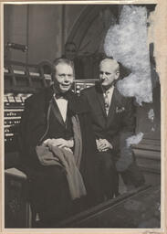 Two men sitting in front of organ