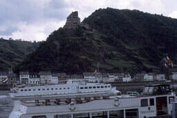 Village pier overlooked by ruins of castle 